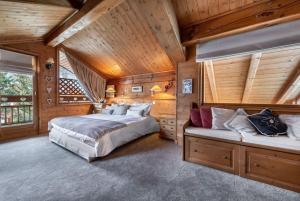 a bedroom with two beds in a wooden cabin at Chalet Les Solans in Les Allues