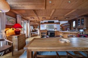 a kitchen with a wooden ceiling with a table and chairs at Chalet Les Solans in Les Allues