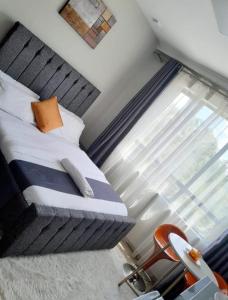 a bedroom with a bed and a window and a chair at Polar homes in Nairobi