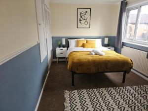 a bedroom with a bed with a yellow blanket at Home in Beckton. Docklands. London City Airport. in London