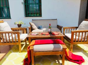 una habitación con sillas y una mesa con una botella de vino en Casa rural Aloha Vera, en Jarandilla de la Vera