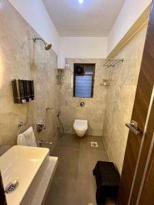 uma casa de banho com um WC e um lavatório em La Olive 1 BHK Service Apartment em Mumbai