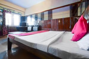 1 dormitorio con 1 cama grande con almohadas rosas en OYO Flagship Hotel Unique en Shimla