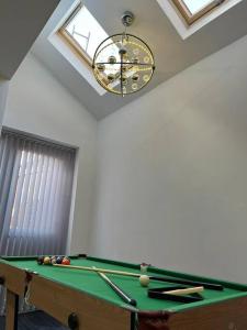 a room with a pool table and a clock at LUXE Villa Near NEC, BHX & Train in Birmingham