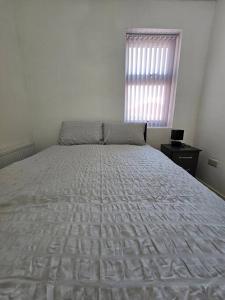a large bed in a bedroom with a window at LUXE Villa Near NEC, BHX & Train in Birmingham