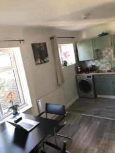 a kitchen with a dining table and a kitchen with a sink at Bright & spacious first floor apartment Cambridge in Chesterton