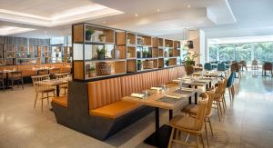 a restaurant with wooden tables and chairs and books at Valamar Diamant Residence in Poreč