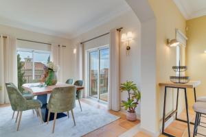 a living room with a table and chairs and a balcony at Villa Gasparini Palheiro Village by Holiday Rental Madeira in São Gonçalo