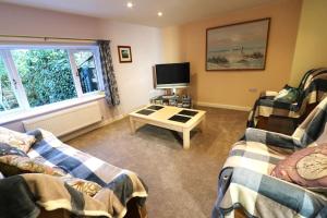 a living room with two couches and a tv at The Old Wagon & Horses 19th Century Beer House in Glastonbury