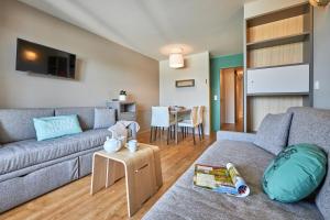 a living room with a couch and a table at Pierre & Vacances Résidence Le Chant des Oiseaux in Courseulles-sur-Mer +56 photos