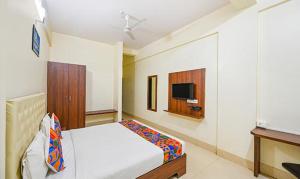 ein Schlafzimmer mit einem Bett und einem TV in der Unterkunft FabHotel Triple Tree in Bhubaneshwar