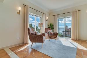 a living room with two chairs and a rug at Villa Gasparini Palheiro Village by Holiday Rental Madeira in São Gonçalo