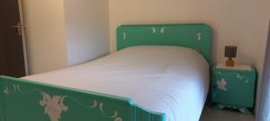 a bed with a green headboard and white sheets at Gîte Bulle de Miel in Berru +7 photos