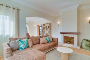a living room with a couch and a fireplace at Villa Gasparini Palheiro Village by Holiday Rental Madeira in Funchal +50 photos
