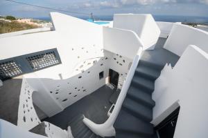 a view of the stairs of a house with the ocean in the background at Santorini traditional 1Bd apt with private hot tub in Fira