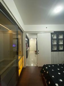 Cette chambre comprend un lit et une porte coulissante en verre. dans l'établissement Apartment Breeze Bintaro, Tangerang Selatan, à Pondoklang