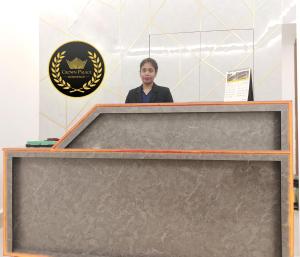 a woman is standing behind a podium at Crown Palace Residence in Dhaka