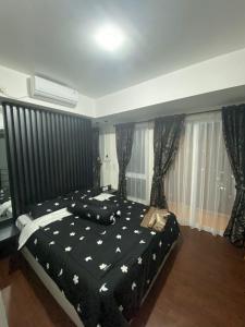 - une chambre avec un lit et une couette noire dans l'établissement Apartment Breeze Bintaro, Tangerang Selatan, à Pondoklang