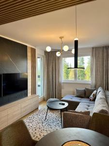 a living room with a couch and a flat screen tv at Massimo Apartment Jahorina Snježna dolina in Jahorina