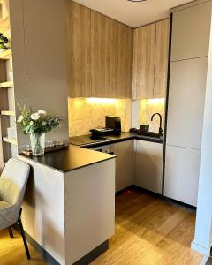 a kitchen with a counter with a vase of flowers at Massimo Apartment Jahorina Snježna dolina in Jahorina