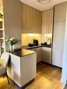 a kitchen with a counter with a vase of flowers at Massimo Apartment Jahorina Snježna dolina in Jahorina