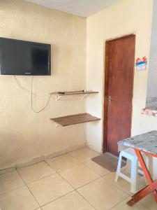 Una habitación con un televisor de pantalla plana en la pared. en kitnetes "Recanto Família Gomes", en Caraguatatuba 85 fotos más