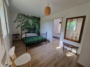 um quarto com uma cama verde e um espelho em La Source, location saisonnière proche Cognac em Saint-André