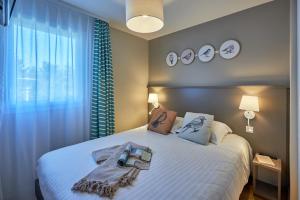 1 dormitorio con 1 cama grande en Pierre & Vacances Résidence Le Chant des Oiseaux, en Courseulles-sur-Mer