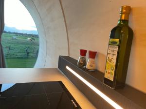 una botella de vino sentada en un estante con dos salsas en Ontspan in de Droomstam, en Dalfsen