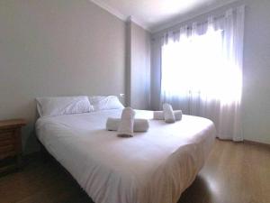 1 dormitorio con 1 cama blanca grande y toallas. en Apartamento El Prado, en Ondara