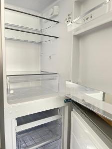 einen weißen Kühlschrank mit offener Tür und Schubladen in der Unterkunft Pension 43 in Duisburg