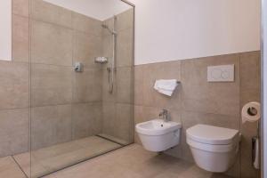 a bathroom with a shower and a toilet and a sink at Ferienwohnungen Karin - Golden in Termeno +21 photos