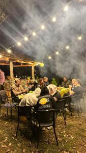 eine Gruppe von Personen, die an Tischen in einem Restaurant im Freien sitzen in der Unterkunft Cottages in mountains in K'veda Bzubzu