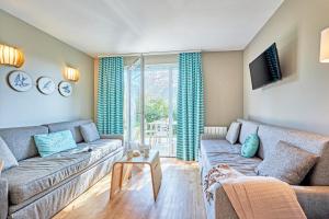 a living room with a couch and a tv at Pierre & Vacances Résidence Le Chant des Oiseaux in Courseulles-sur-Mer