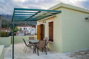 a patio with a table and chairs on a house at Traditional house in Fres in Karés