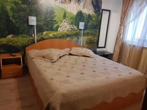 a bedroom with a bed and a painting on the wall at Apartament Silva Busteni in Buşteni