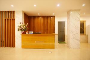 um átrio do hotel com uma recepção e flores em GEM Apartment & Hotel em An Khê