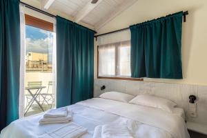 a bedroom with a large bed with blue curtains and a window at Mooeve Exarchia in Athens