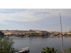 una barca seduta su un lago con una barca a vela di Labib Guest House a Aswan