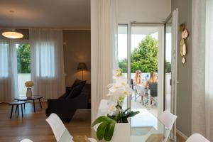 Casa DP في كونيليانو: غرفة معيشة مع طاولة زجاجية مع كراسي بيضاء
