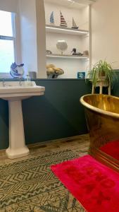 a bathroom with a sink and a toilet and a table at The Totnes Guest House. Upstairs at Zappa's in Totnes