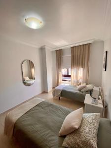 Habitación de hotel con 2 camas y espejo en Vivienda Vacacional La Alameda, en Santa Cruz de la Palma
