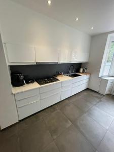 - une cuisine blanche avec des placards blancs et un évier dans l'établissement Luxurious House in Kerkrade Center, à Kerkrade