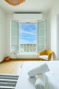 1 dormitorio con cama, ventana y silla en Fac 6 - Vue Garonne - Tram - Parking, en Toulouse