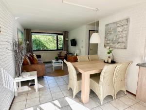 een eetkamer en een woonkamer met een tafel en stoelen bij Noordzeehuisje in Sint Maartensvlotbrug