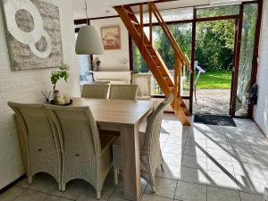 een eetkamer met een houten tafel en stoelen bij Noordzeehuisje in Sint Maartensvlotbrug