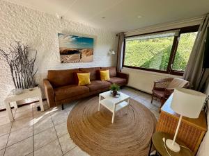 a living room with a couch and a table at Noordzeehuisje in Sint Maartensvlotbrug