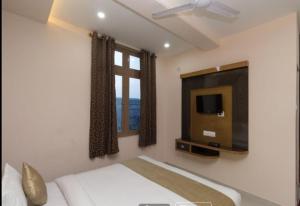 1 dormitorio con 1 cama y TV de pantalla plana en Hotel Shillong Vibe, en Shillong