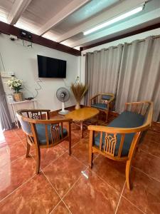 een woonkamer met stoelen en een tafel en een televisie bij บ้านยายโฮมเทล Baan yai hometel in Nakhon Phanom