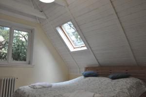 a bedroom with a bed in a attic with two windows at House near to Schönbrunn - Free Parking - 24-7 Check in - 8 Person in Vienna
